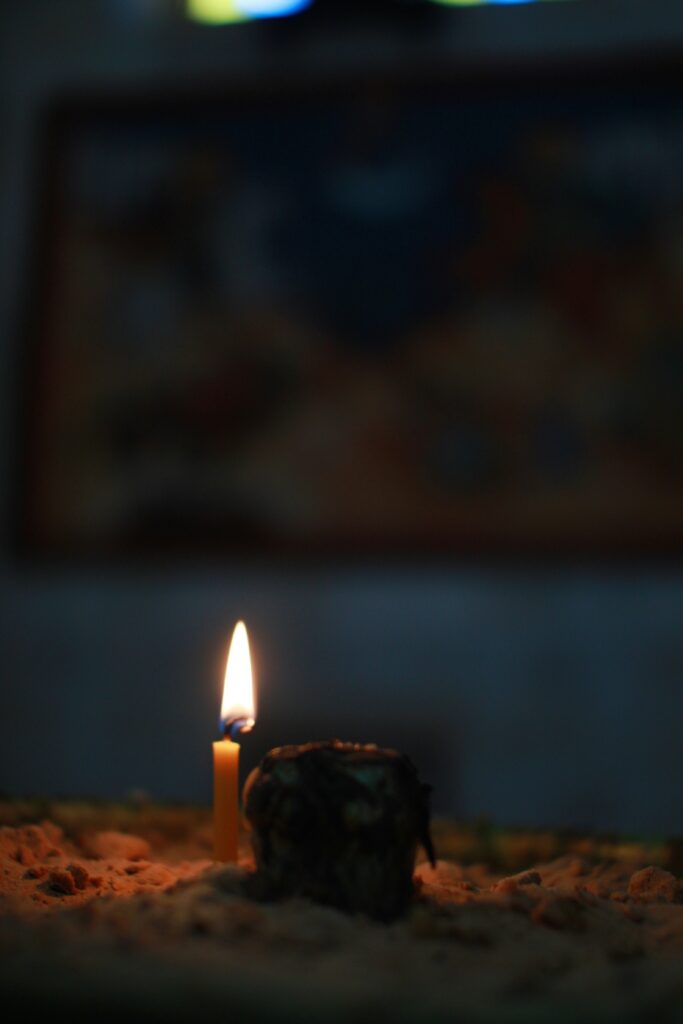 Lit candle on wooden surface — contemplative light